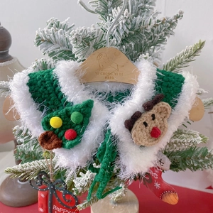 Handmade green knit pet Christmas scarf with reindeer and tree decor on a wooden hanger