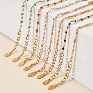 Close-up of gold stainless steel bracelets with colorful enamel beads and lobster clasp