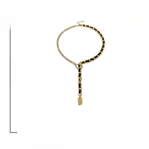 Dettaglio della collana a Y dorata con catena di strass e nastro nero intrecciato