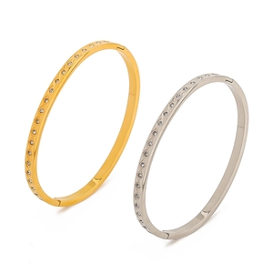 Dettaglio di bracciali in acciaio inossidabile oro e argento con zirconi brillanti