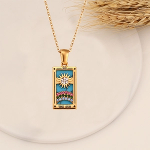 Macro detail of gold tarot sun pendant featuring colorful cubic zirconia and XIX engraving