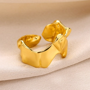 Macro view of gold open ring featuring irregular lava texture on textured fabric