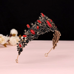 Detailed side view of baroque bridal crown with red and black gems on gold alloy