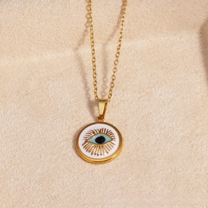 Close-up of golden Evil Eye necklace with blue iris pendant on a soft beige background