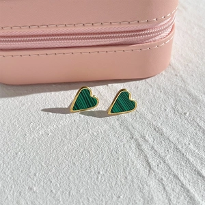 Détail de boucles d'oreilles cœur avec texture malachite verte et monture dorée