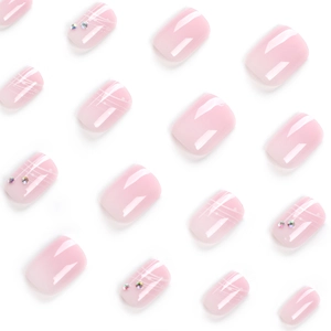 Short french press-on nails with pink gradient design and sparkling crystal accents