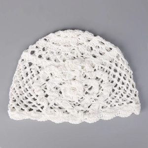 Détail du bonnet au crochet avec perle centrale et motif de maille ajourée sophistiqué