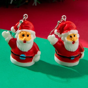 Close-up of festive red and white Santa Claus stud earrings with Christmas theme background