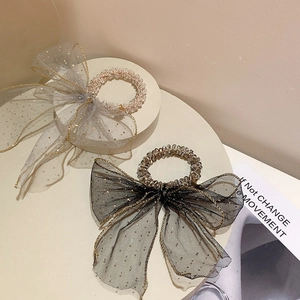 Detail of beaded hair ties with sheer mesh bows and gold sequin polka dots