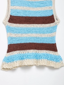 Macro detail of the blue and brown striped knit vest showing the ruffled hem texture