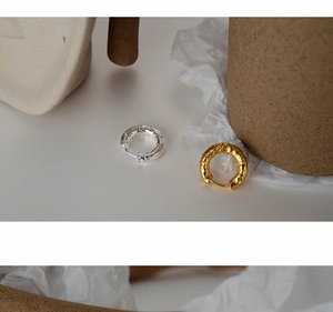 Macro detail of silver and gold hoop earrings with unique hammered crinkle texture