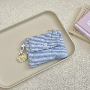 Detail of blue striped quilted coin purse with heart patterns and bear charm
