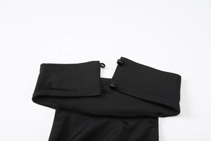 Detailed view of black halter neck dress with spherical buttons and stitching