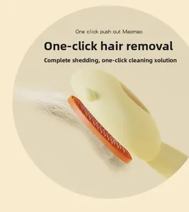 Detail of pet grooming brush with one-click hair release button and orange bristles