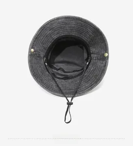 Detail of washed denim bucket hat interior with adjustable sweatband and windproof cord