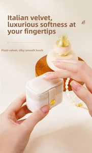 Macro detail of compact cream velvet jewelry box with soft touch and gold snap button