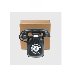 Close-up of vintage black rotary phone model with detailed dial and craft packaging