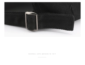 Detail of a black cotton baseball cap showing the adjustable matte metal back buckle