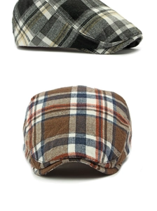 Close-up of vintage plaid beret caps showing classic black-grey and brown-orange patterns