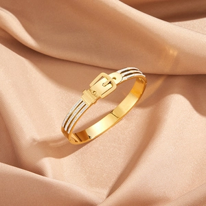 Macro shot of gold belt buckle bracelet with Fashion engraving and micro-set diamonds