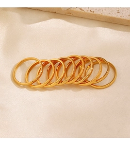Set of eight minimalist golden stainless steel rings on elegant silk and stone