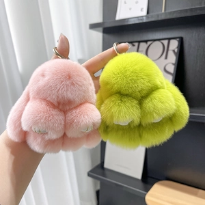 Detailed view of two fluffy faux fur bunny keychains in vibrant pink and neon green colors