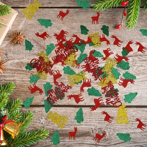 Close-up of Christmas confetti with red reindeer and glitter trees on wood background