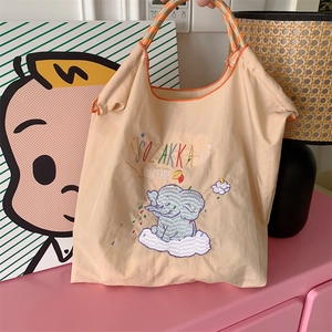 Detail of cute elephant embroidery and orange woven handle on oxford cloth tote bag
