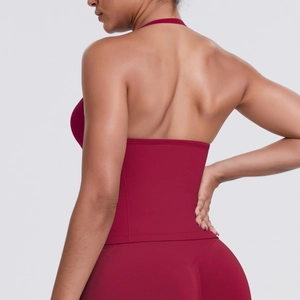 Detail of cross-back sports bra and high-waisted leggings in deep red yoga fabric