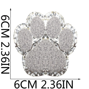 Detail showing a 6cm gray puppy paw embroidery patch with silver sequin border details