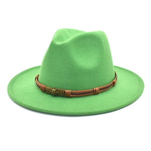 Detail of green wool fedora with a braided band and vintage bronze skull buckle decoration