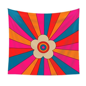 Detail of retro bohemian tapestry featuring floral patterns and vibrant radial sunbeams