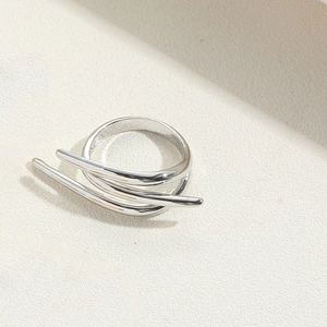Detailed view of a silver double-layered minimalist ring on a textured surface