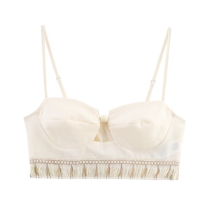 Detail of bohemian cream crop top featuring tassels and intricate woven embroidery