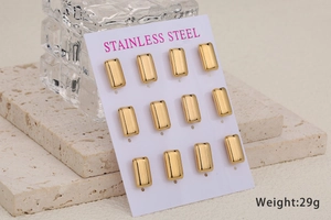 Detail view of 12 pieces of golden stainless steel rectangle studs on a stone pedestal