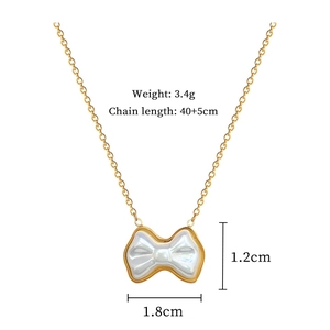 Detailed view of gold bow necklace with pearl inlay, 3.4g weight and 40cm chain length