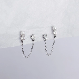 Close-up of 925 silver double earring with pearl, crystals, and delicate tassel chain