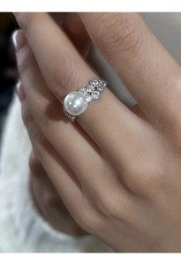 Detailed close-up of a sterling silver pearl ring with sparkling zircon sugar cube accents