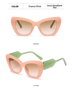 Detail view of pink cat eye sunglasses with light green temples and brown gradient lenses