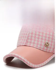 Détail de la casquette pied-de-poule rose avec badge M en strass et visière courbée