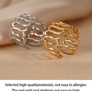 Macro shot of wavy hollow open rings in polished gold and silver stainless steel