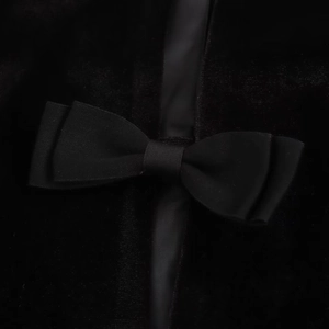 Elegante vestido de cóctel de terciopelo negro con detalle de lazo decorativo al frente
