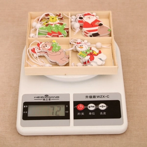 Wooden Christmas pendants in a storage box weighing 72g on a scale for festive decor