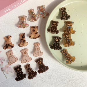 Cute cartoon bear and rabbit hair clips set in assorted colors on a ceramic plate