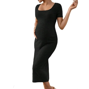 Détail de la robe de maternité noire en maille avec texture côtelée et fente latérale