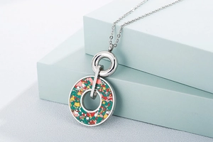 Close-up of a silver double ring pendant with colorful crushed stone inlay detail