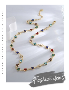 Detailed shot of gold chain necklace with colorful heart-shaped zircon and lobster clasp