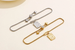 Detail of adjustable square chain bracelets with heart and moon engraved charms