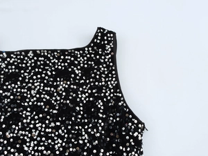 Close-up of sparkling silver sequins on black sleeveless party dress shoulder detail