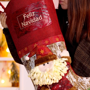 Large red Christmas stocking with 3D Santa and Feliz Navidad greeting held by a person